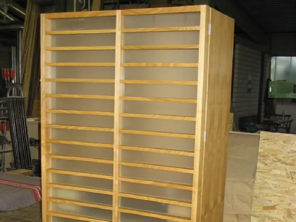 Schrank aus hellem Holz mit Lamellenfront